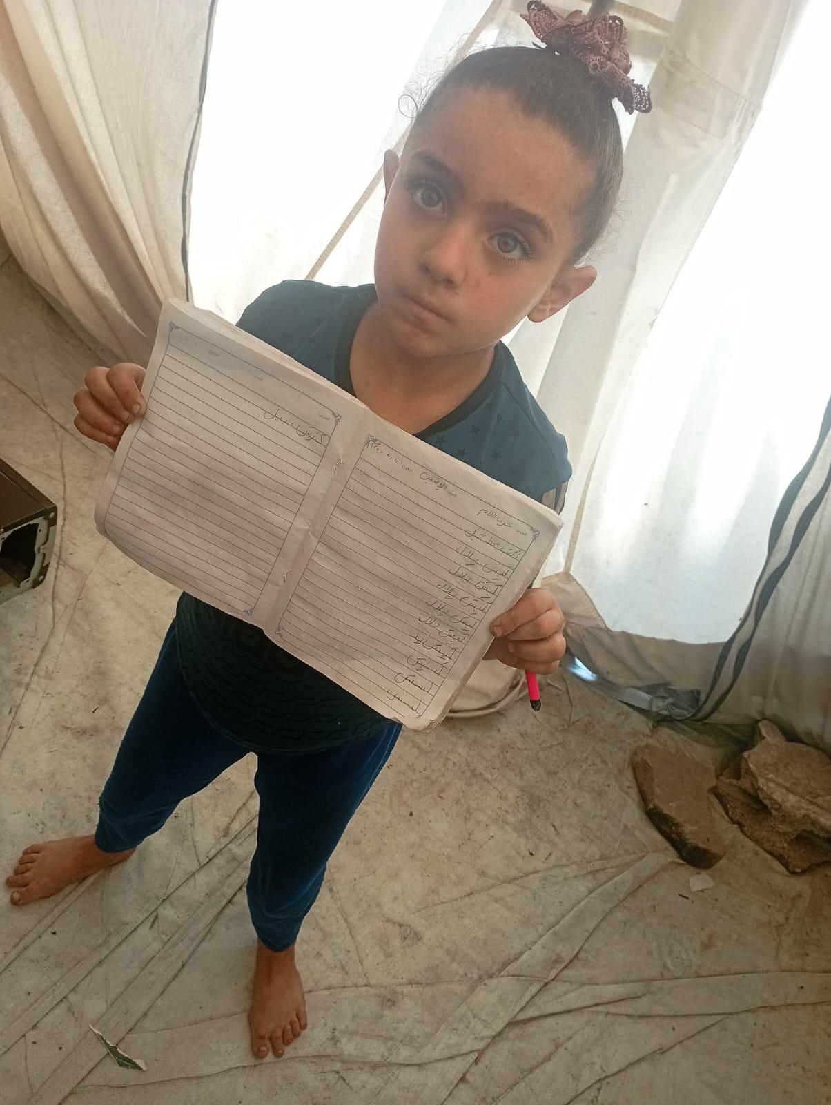 Girl showing her handwritten notebook