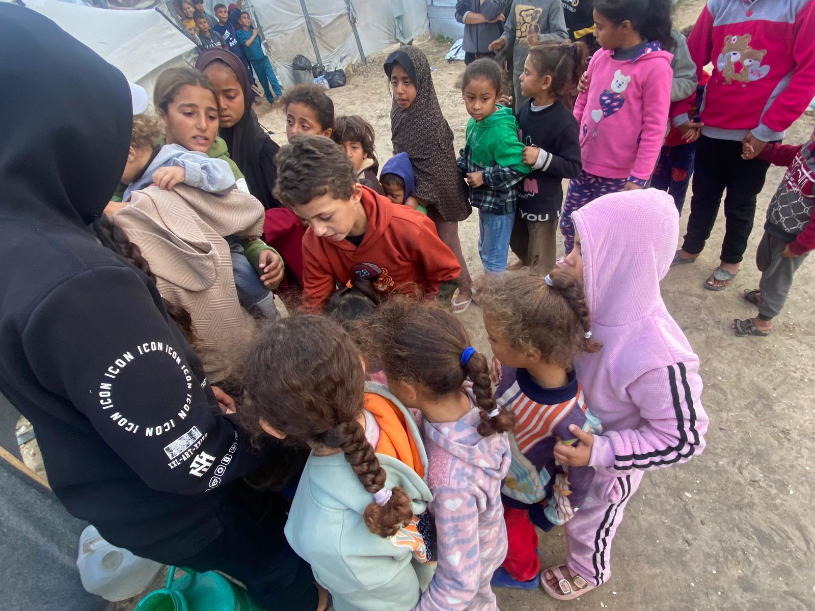 Volunteer handing out supplies to a group of children