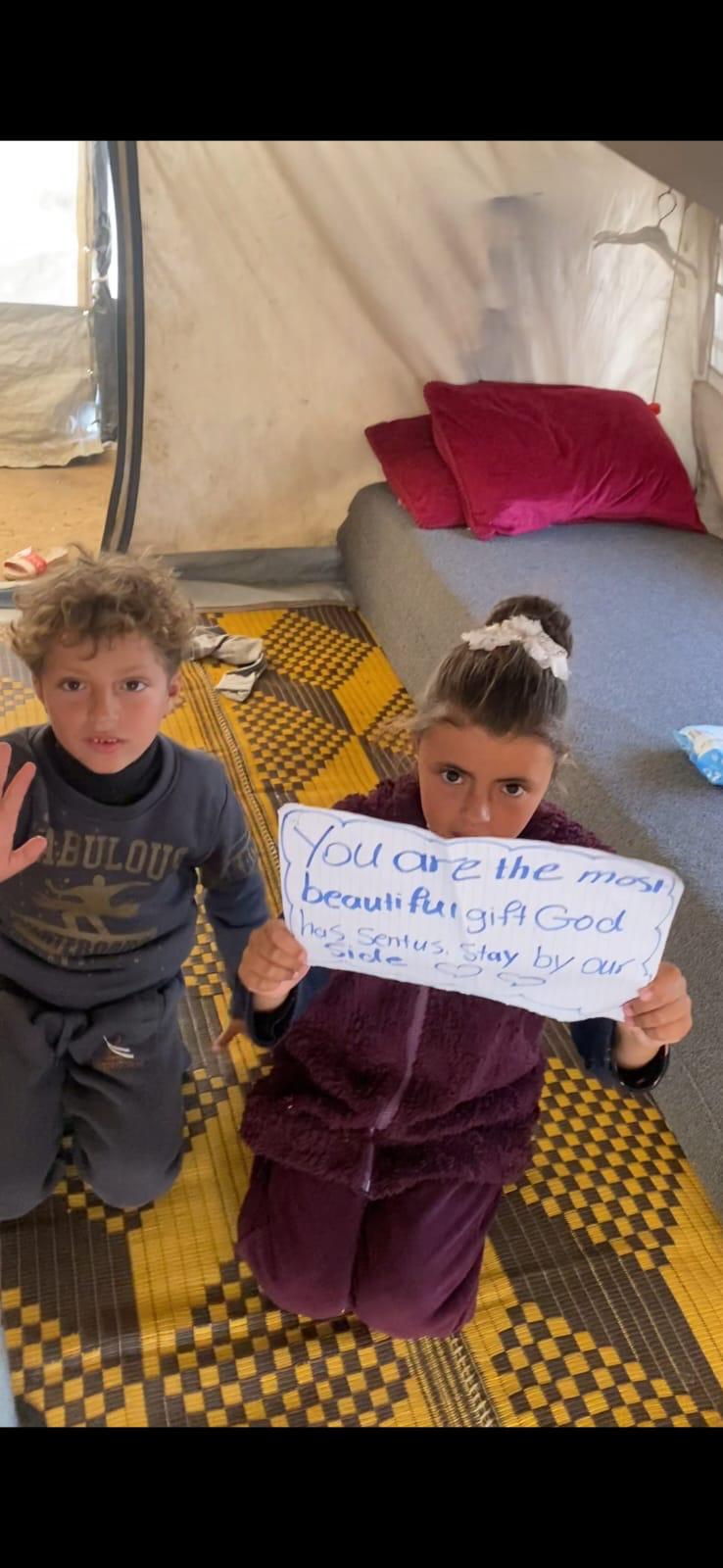 Children holding a handwritten thank-you sign